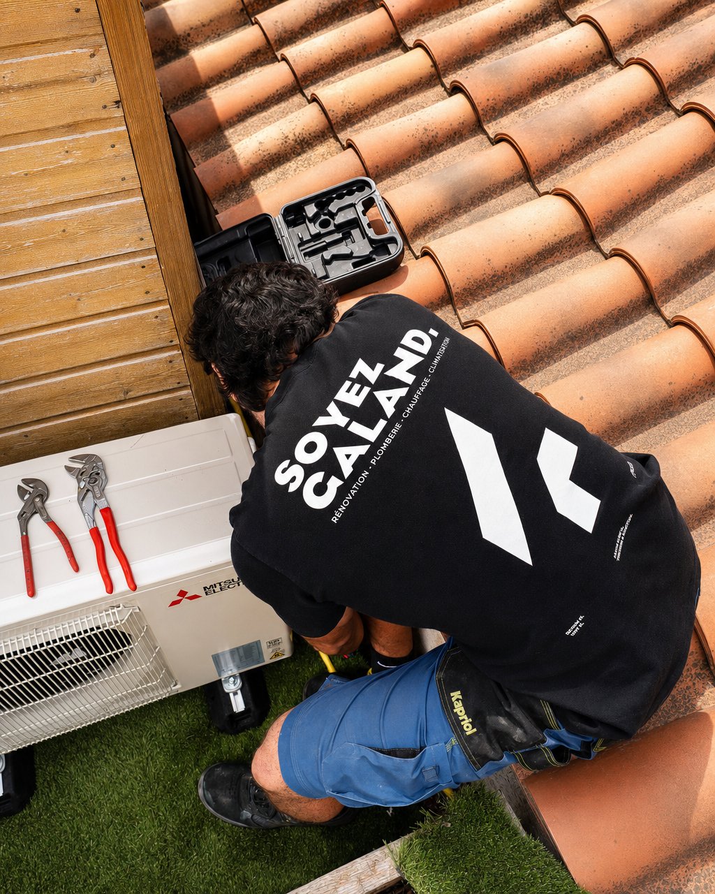 Technicien GALAND installant une climatisation Mitsubishi Electric sur une toiture marseillaise